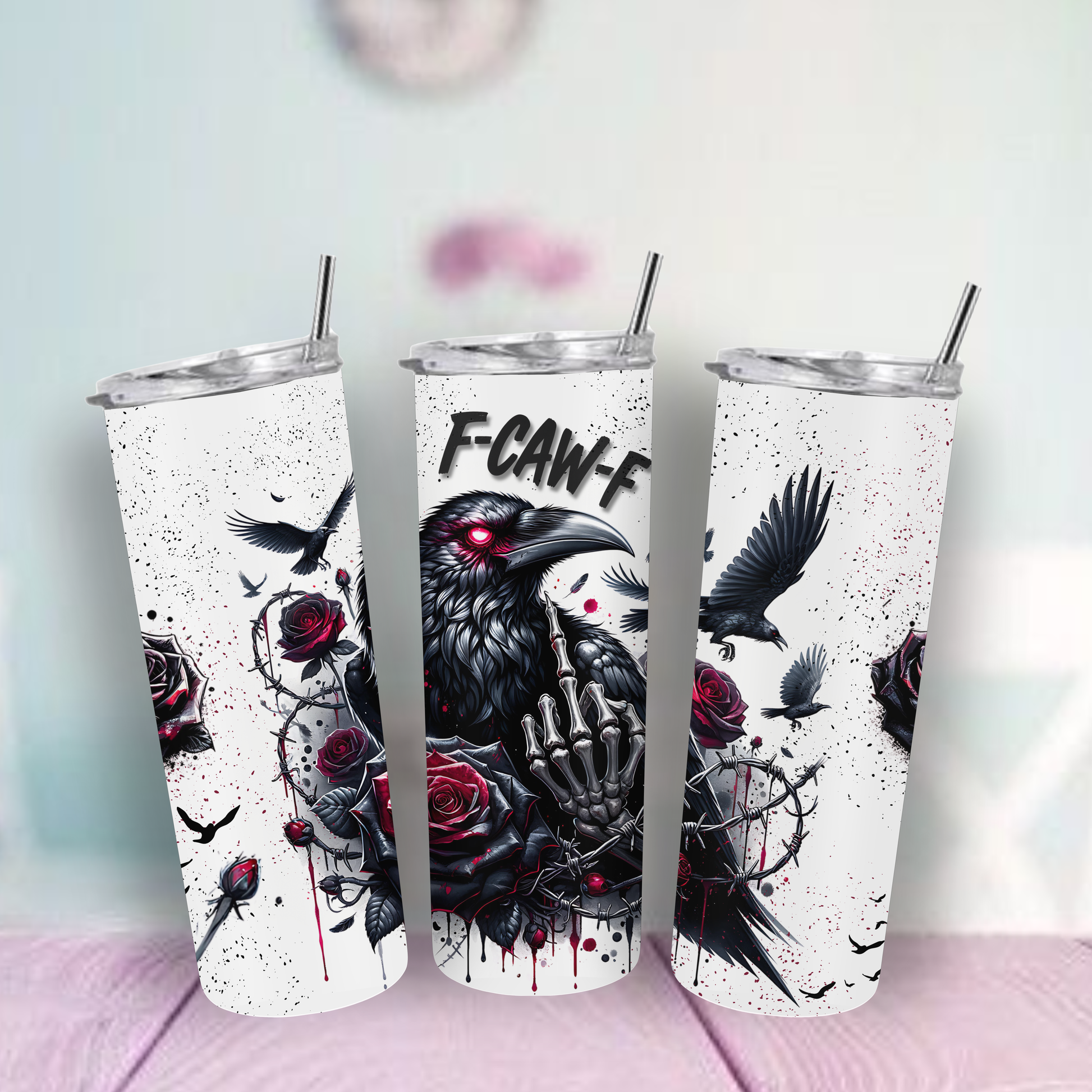 Tumbler with a design of a black bird, roses, and a hand middle finger up on a light surface.