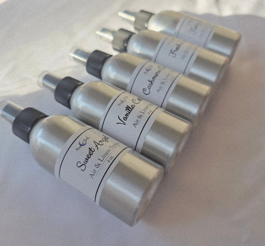 Set of silver bottles with black nozzles on a white surface